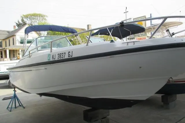 Slide: The Image of 1999 Boston Whaler 20 Ventura Bowrider on display, featuring sleek design and blue canopy. - 10