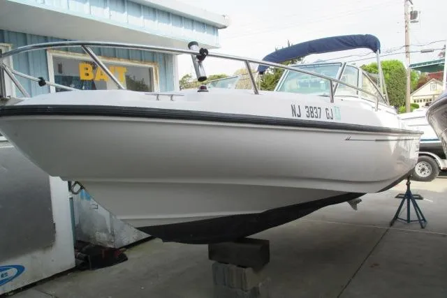 Slide: The Image of 1999 Boston Whaler 20 Ventura Bowrider on display, white hull, parked outdoors. - 11
