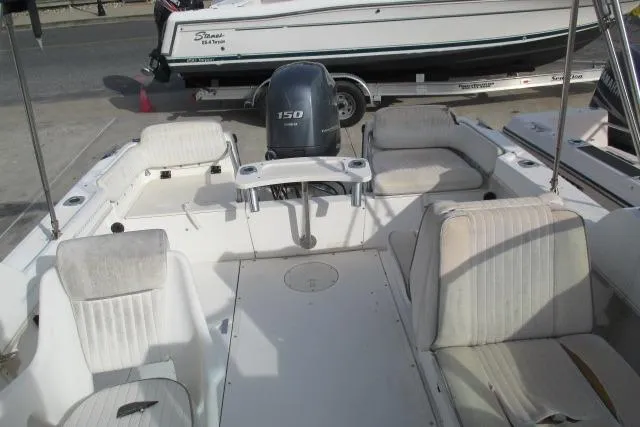 Slide: The Image of 1999 Boston Whaler 20 Ventura Bowrider with seating and 150 HP engine, docked outdoors. - 16