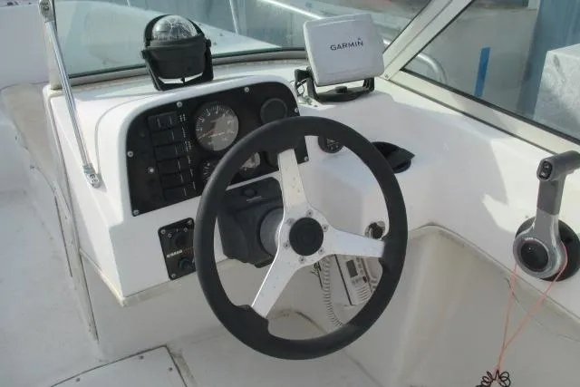 Slide: The Image of 1999 Boston Whaler 20 Ventura Bowrider dashboard with steering wheel and Garmin navigation system. - 2