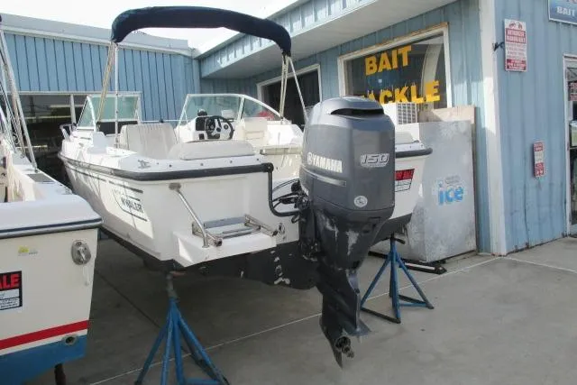 Slide: The Image of 1999 Boston Whaler 20 Ventura Bowrider with Yamaha 150 engine, displayed outside bait shop. - 9