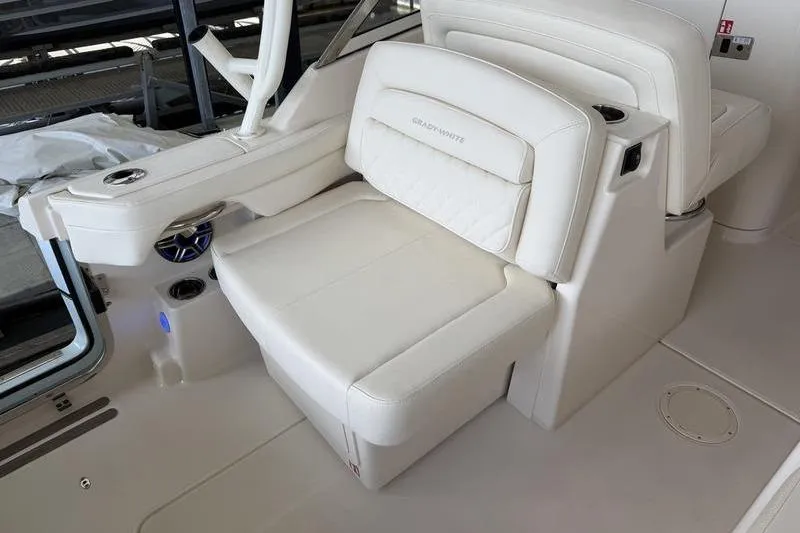 Slide: The Image of Luxury seating on 2026 Grady-White Freedom 285 boat, featuring white upholstery and cup holders. - 13