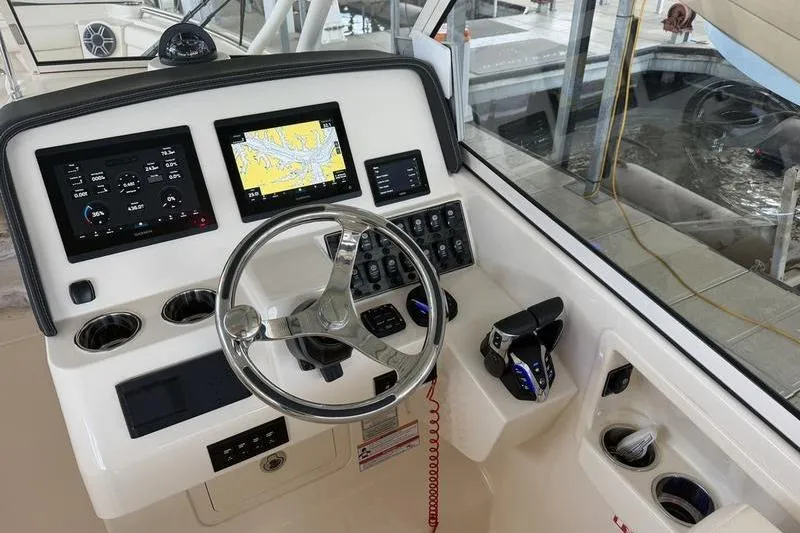 Slide: The Image of Helm of 2026 Grady-White Freedom 285 with modern navigation displays and controls. - 17