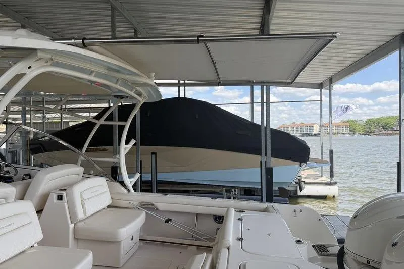 Slide: The Image of 2026 Grady-White Freedom 285 boat docked under a covered marina with scenic lake view. - 20
