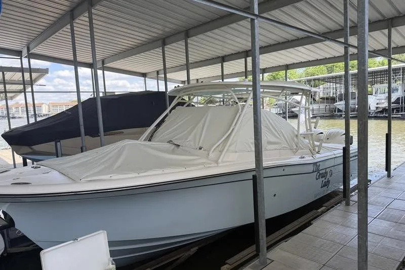 Slide: The Image of 2026 Grady-White Freedom 285 boat docked under a covered marina. - 23