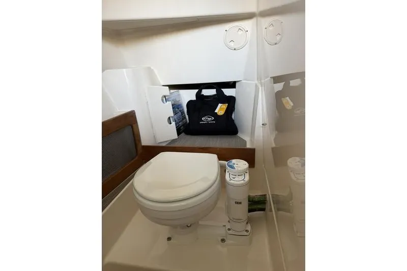 Slide: The Image of Interior of 2026 Grady-White Freedom 285 boat featuring a compact marine toilet. - 24