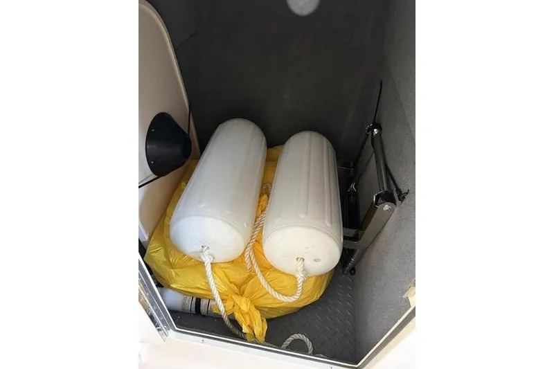 Slide: The Image of Storage compartment of 2026 Grady-White Freedom 285 with boat fenders and yellow bag. - 25