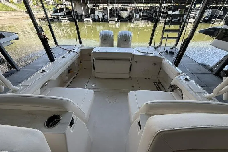 Slide: The Image of 2026 Grady-White Freedom 285 boat interior with seating and twin engines at dock. - 27