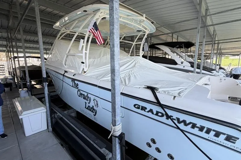 Slide: The Image of 2026 Grady-White Freedom 285 boat docked under a covered marina with protective cover. - 5
