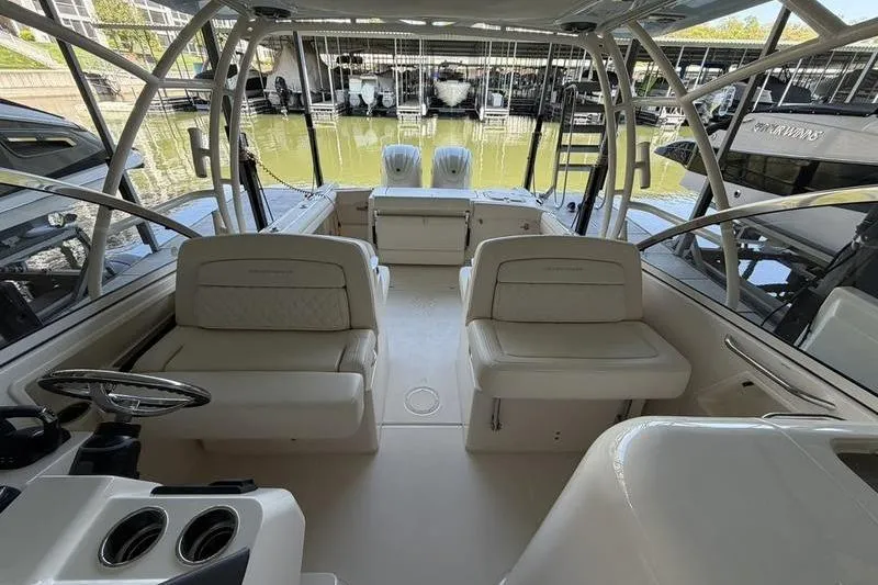 Slide: The Image of 2026 Grady-White Freedom 285 boat interior with seating and helm, docked at marina. - 7