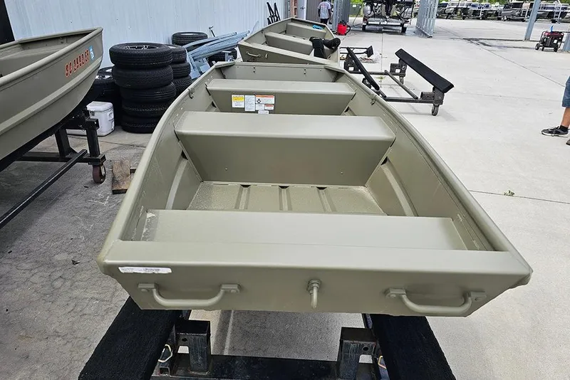 Slide: The Image of 2026 Tracker Grizzly 12 Jon boat displayed on a trailer in a showroom. - 5