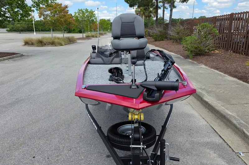 Slide: The Image of 2026 Tracker Pro 170 boat on trailer, parked on a street with trees in background. - 10