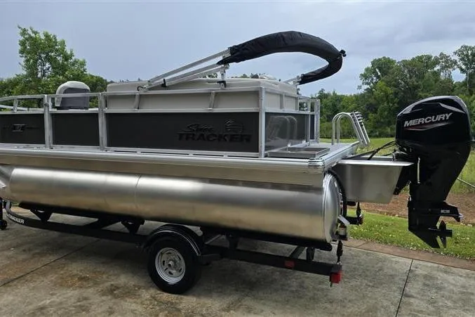 Slide: The Image of 2026 Sun Tracker Bass Buggy 16 XL Select pontoon boat with Mercury outboard motor on trailer. - 3