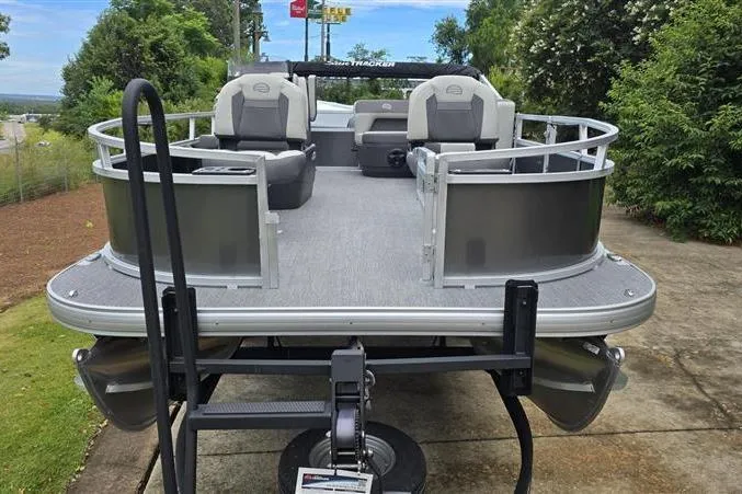 Slide: The Image of 2026 Sun Tracker Bass Buggy 16 XL Select pontoon boat on trailer, parked outdoors. - 7