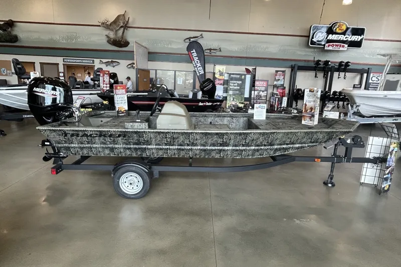 The Image of 2026 Tracker Grizzly 1648 SC boat displayed indoors with Mercury engine. - 0