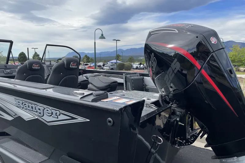Slide: The Image of 2026 Ranger VX1888 WT boat with powerful outboard motor, parked outdoors under cloudy sky. - 2