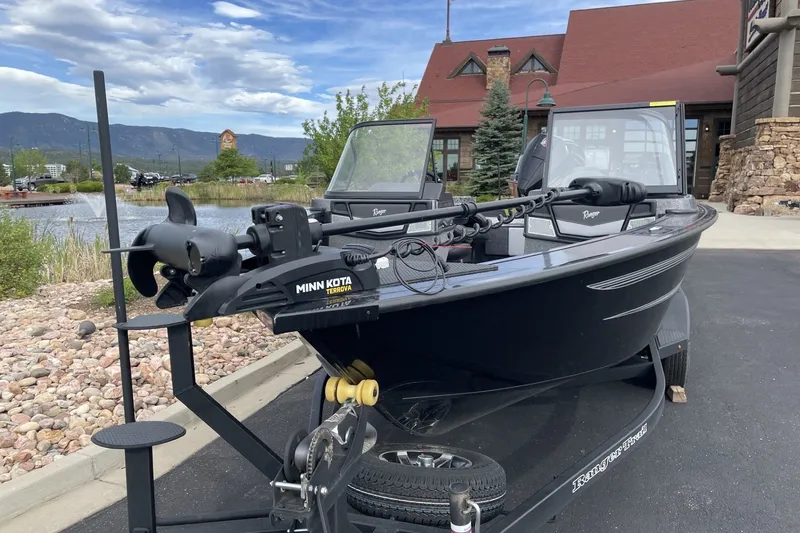 Slide: The Image of 2026 Ranger VX1888 WT boat with Minn Kota motor, parked near a scenic lake. - 1
