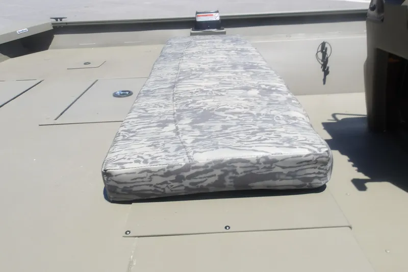 Slide: The Image of 2026 Tracker Grizzly 2072 CC boat interior with camo-patterned cushion on deck. - 7
