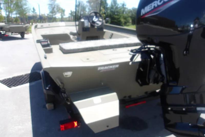 Slide: The Image of 2026 Tracker Grizzly 2072 CC boat with Mercury engine, parked outdoors. - 3