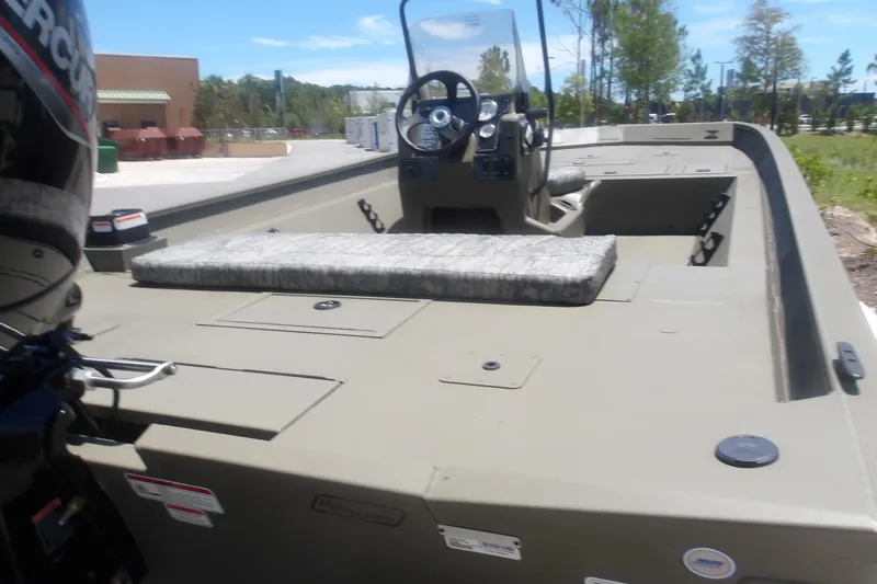Slide: The Image of 2026 Tracker Grizzly 2072 CC boat with console and seating, parked outdoors. - 5