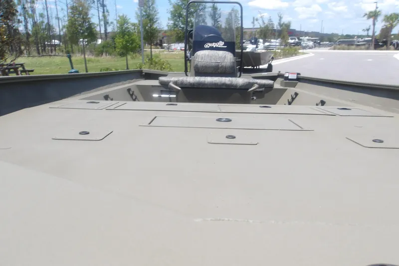 Slide: The Image of 2026 Tracker Grizzly 2072 CC boat with spacious deck and seating, parked outdoors. - 11