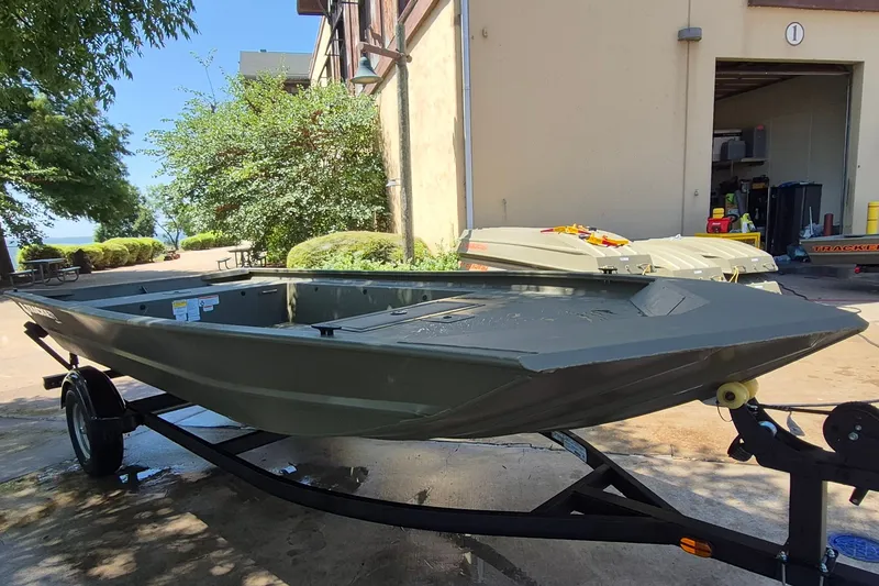 Slide: The Image of 2026 Tracker Grizzly 1754 Utility boat on trailer, outdoors near building. - 3