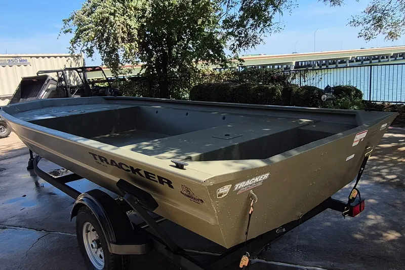 Slide: The Image of 2026 Tracker Grizzly 1754 Utility boat on trailer, parked near a waterfront. - 7