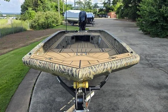 Slide: The Image of 2026 Tracker Grizzly 1650 T Prairie Wings Edition boat on trailer, camo design, parked outdoors. - 2