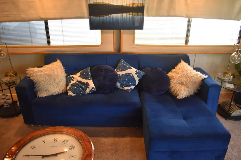 Slide: The Image of Luxurious blue sofa with decorative pillows in a 1996 Stardust Cruisers houseboat interior. - 10