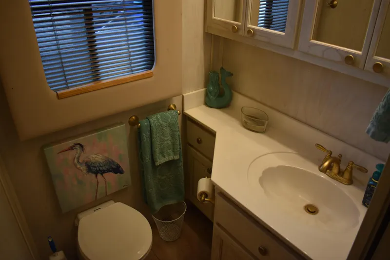 Slide: The Image of Bathroom interior of 1996 Stardust Cruisers houseboat with heron artwork and teal accents. - 19