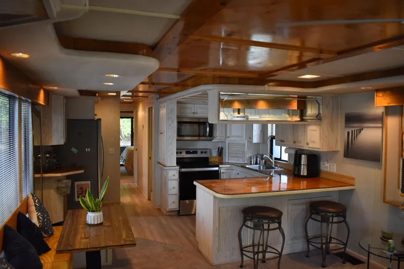 Slide: The Image of Interior of a 1996 Stardust Cruisers houseboat with modern kitchen and dining area. - 4