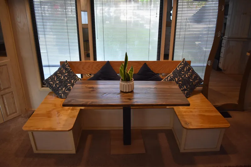 Slide: The Image of Cozy dining area in 1996 Stardust Cruisers houseboat with wooden table and cushioned seating. - 6
