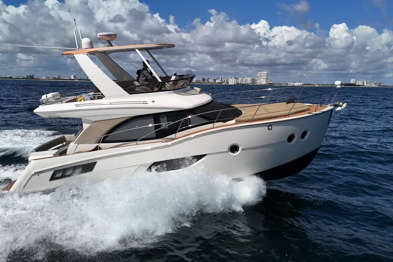 The Image of 2014 Carver 40 Command Bridge yacht cruising on open water under a partly cloudy sky. - 0