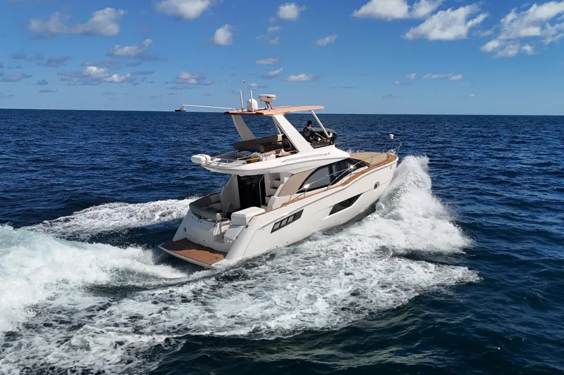 Slide: The Image of 2014 Carver 40 Command Bridge yacht cruising on open sea under blue sky. - 16