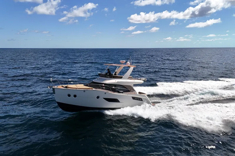 Slide: The Image of 2014 Carver 40 Command Bridge yacht cruising on open sea under blue sky. - 21