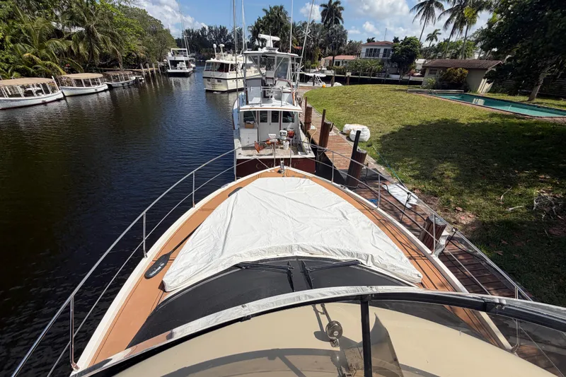 Slide: The Image of 2015 Carver 40 Command Bridge yacht docked in a scenic marina setting. - 35