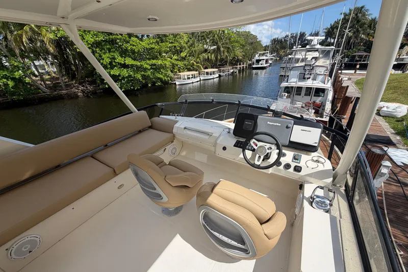 Slide: The Image of 2015 Carver 40 Command Bridge yacht helm with dual seats, docked by a scenic canal. - 39