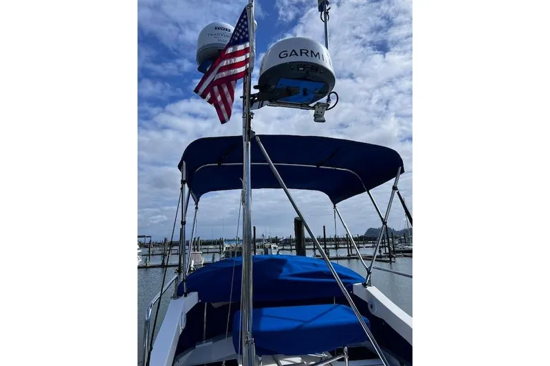 Slide: The Image of 2021 Ranger Tugs R-31 CB boat with blue canopy and radar, docked under cloudy sky. - 10