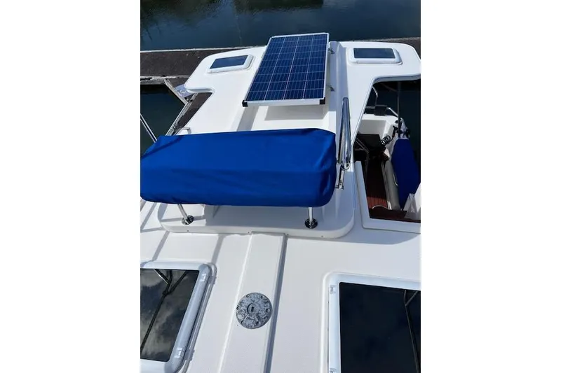 Slide: The Image of 2021 Ranger Tugs R-31 CB boat with solar panel and blue cover on deck. - 13