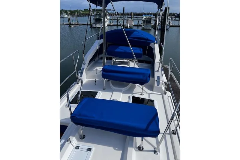 Slide: The Image of 2021 Ranger Tugs R-31 CB boat deck with blue cushioned seating at marina. - 16