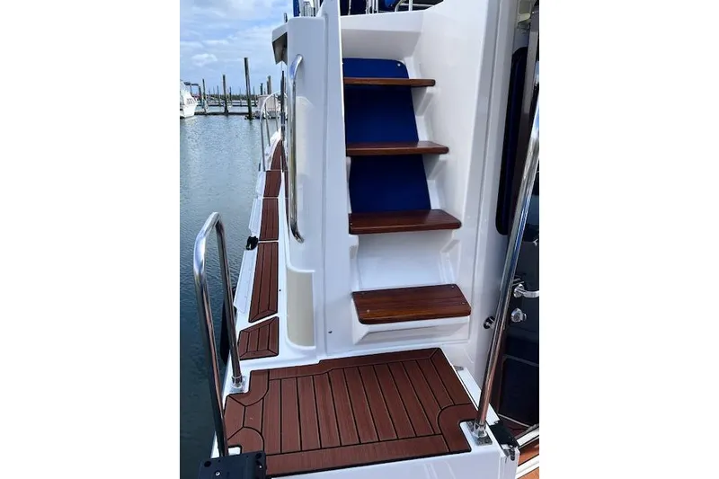 Slide: The Image of 2021 Ranger Tugs R-31 CB boat with wooden steps and deck, docked at marina. - 21
