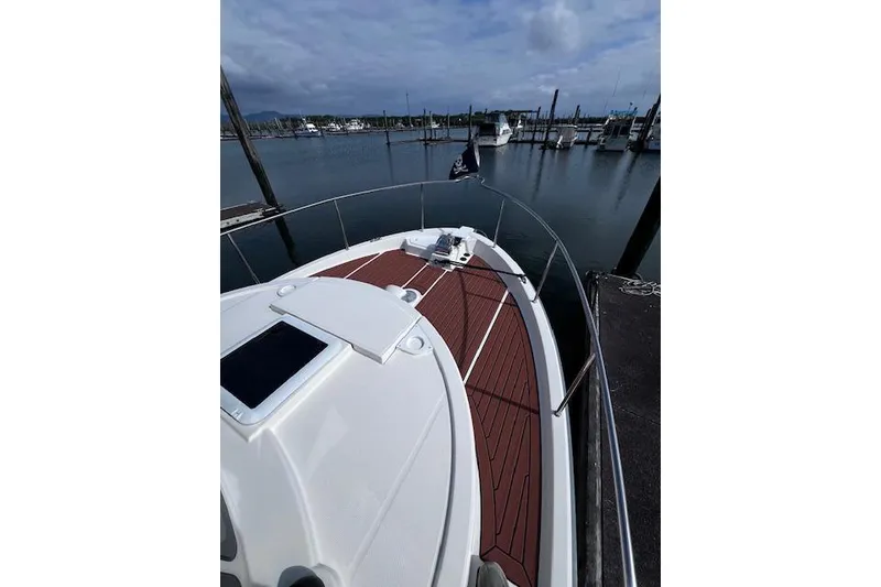 Slide: The Image of 2021 Ranger Tugs R-31 CB boat docked in a marina, featuring a sleek deck design. - 24