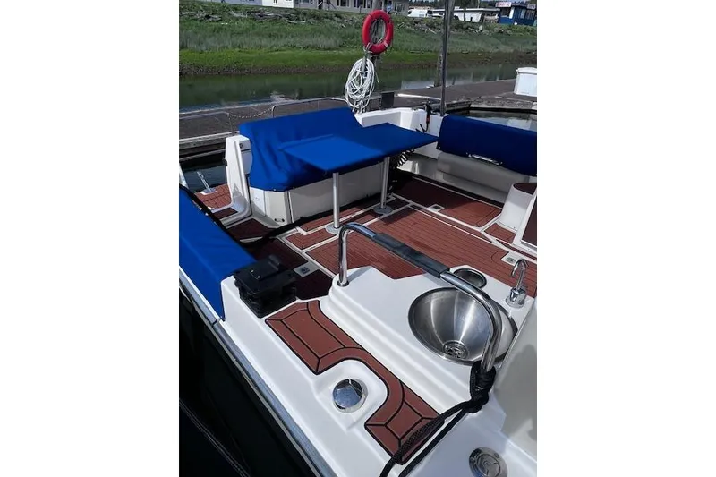 Slide: The Image of 2021 Ranger Tugs R-31 CB boat deck with seating, sink, and blue covers. - 26