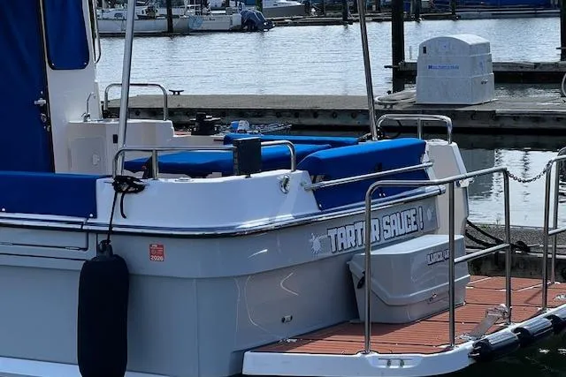 Slide: The Image of 2021 Ranger Tugs R-31 CB docked at marina with blue seating and railing. - 27