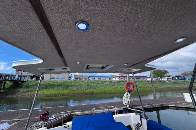 Slide: The Image of 2021 Ranger Tugs R-31 CB boat deck with canopy, docked by a riverside. - 29