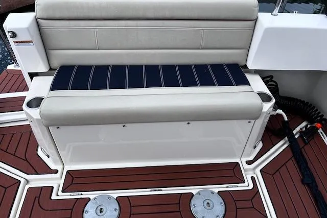 Slide: The Image of 2021 Ranger Tugs R-31 CB boat seating with striped cushion on wooden deck. - 35