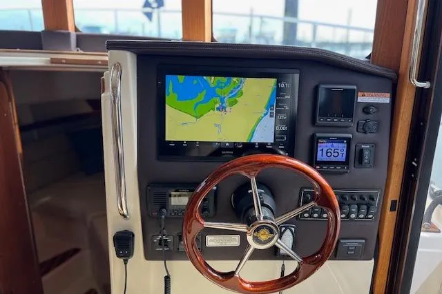 Slide: The Image of 2021 Ranger Tugs R-31 CB helm with navigation display and wooden steering wheel. - 36