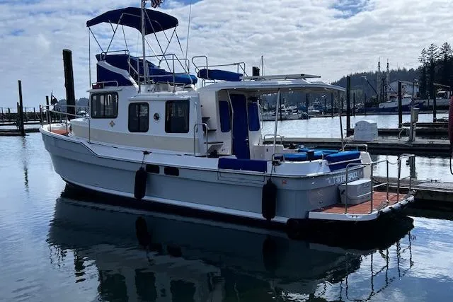 Slide: The Image of 2021 Ranger Tugs R-31 CB boat docked in a marina under a cloudy sky. - 4