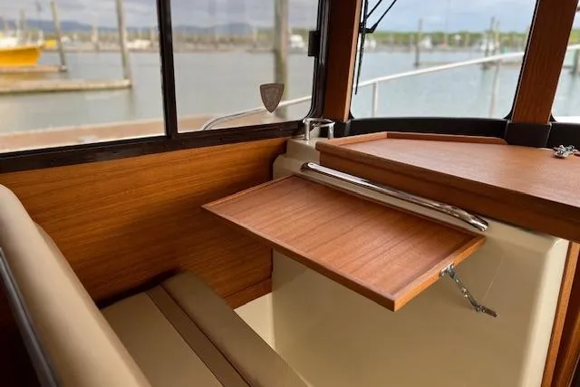 Slide: The Image of Interior of 2021 Ranger Tugs R-31 CB with wooden table and seating by a window. - 42