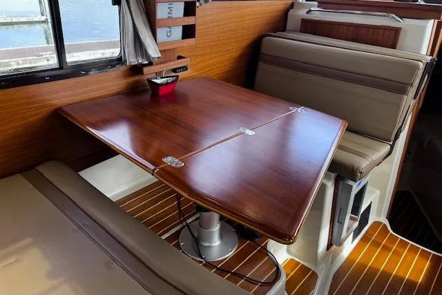 Slide: The Image of Interior of 2021 Ranger Tugs R-31 CB with wooden table and cushioned seating. - 43